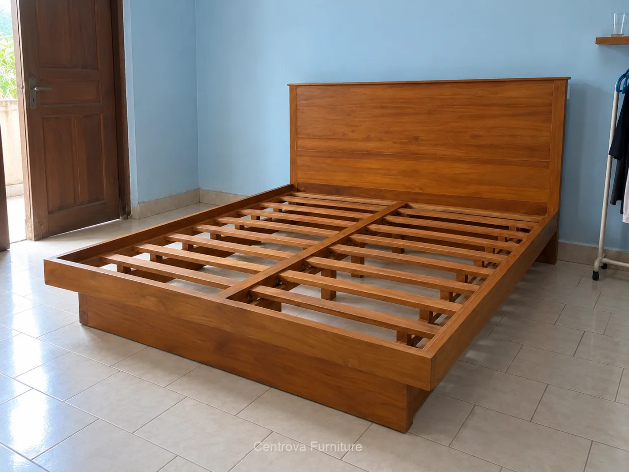 Rangka dipan kayu dengan kepala polos dan penopang kasur terbuka dalam kamar sederhana.