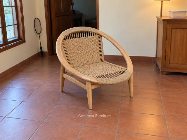 Kursi kayu berbingkai bulat dengan anyaman dalam ruang rumah sederhana.